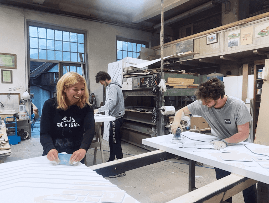 From office to workshop. Sanding with purpose as everyone steps in to help, no matter their role or title.