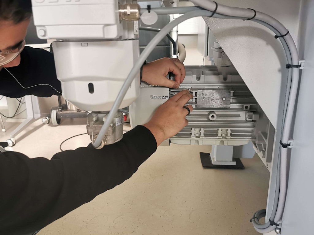 A student mounts a thermoelement on the machine components - in this case cooling ribs of the primary motor.
