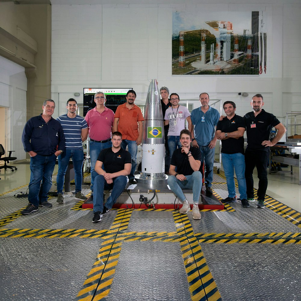 Dewesoft and DCTA engineering teams pose next to a rocket cone in the test lab
