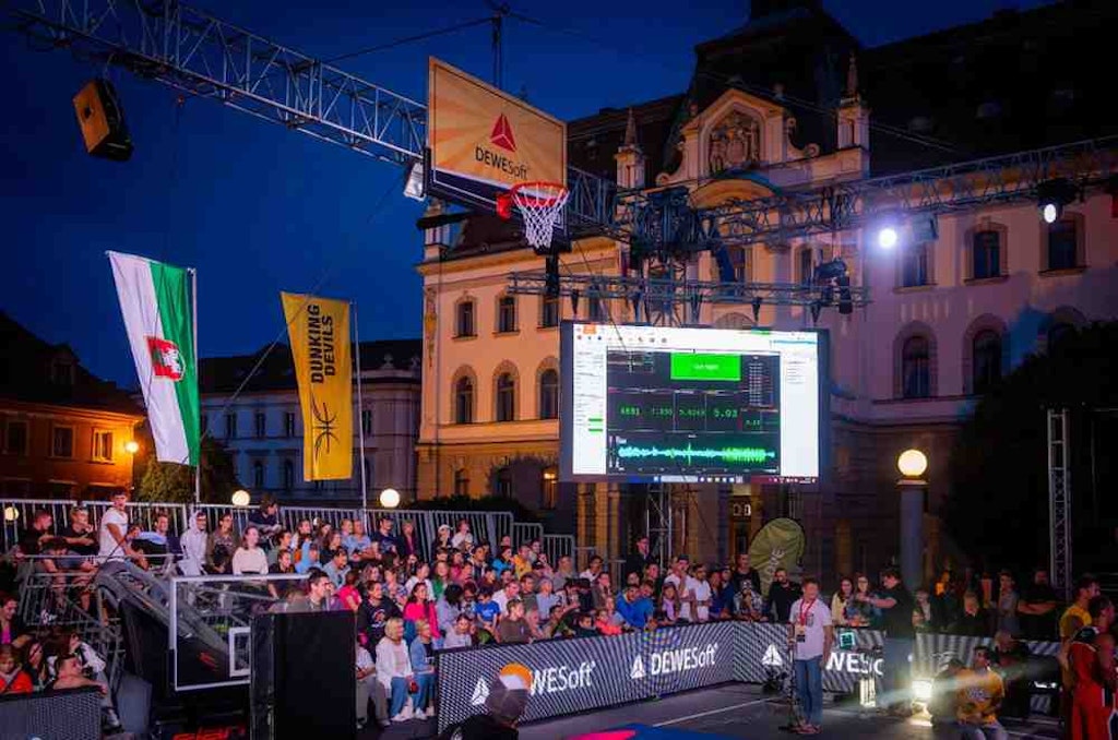 Figure 6. The action is on! The event arena with the hoop rigged for measurement and a big screen displaying the results.