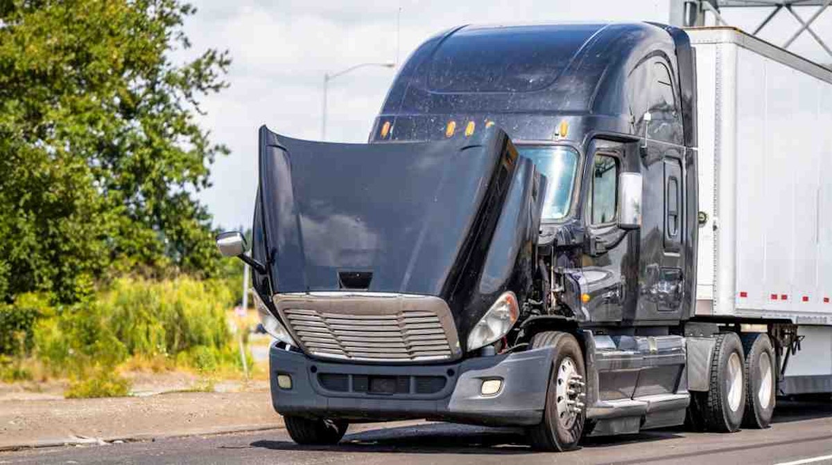 Truck with open hood on a road