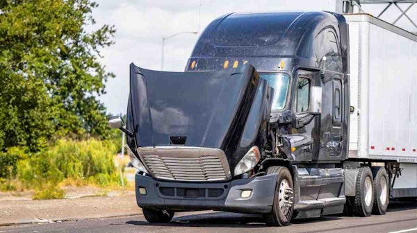 Truck with open hood on a road
