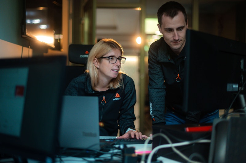 Dewesoft employees Sara and Dore collaborating at a computer workstation in a technical office environment.