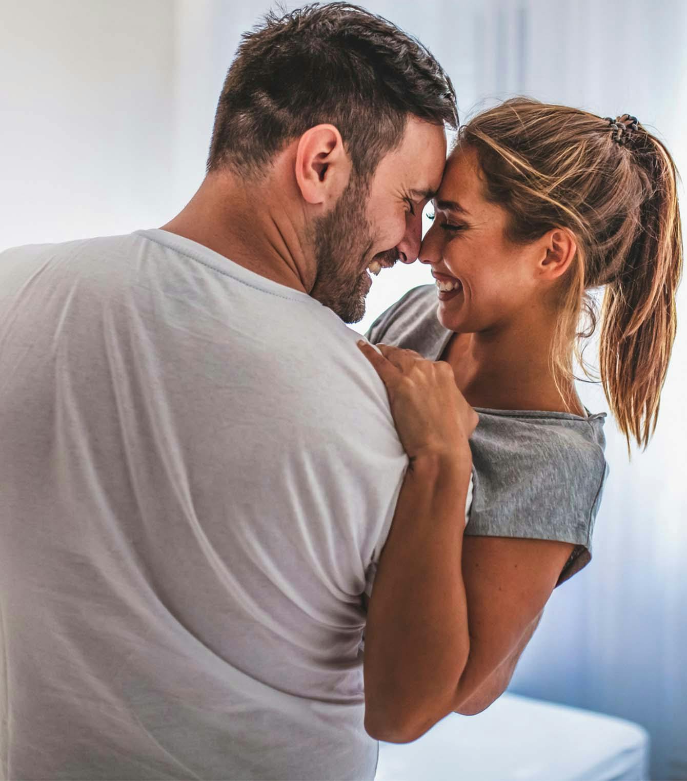 Man and woman smiling, hugging
