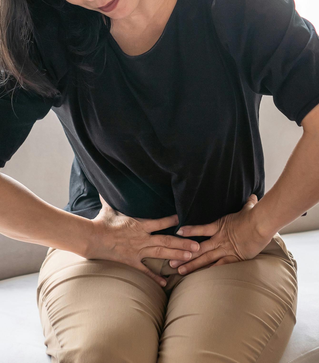 Woman holding her lower abdominal area in pain