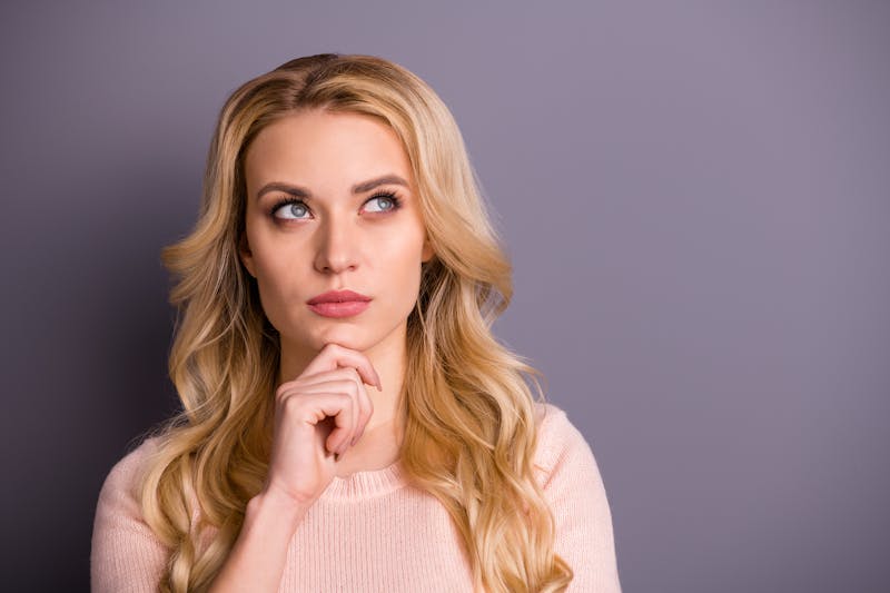 Woman with Blonde Hair and a Pink Sweater Thinking