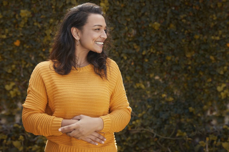 Woman in Yellow Sweater Holding Her Stomach