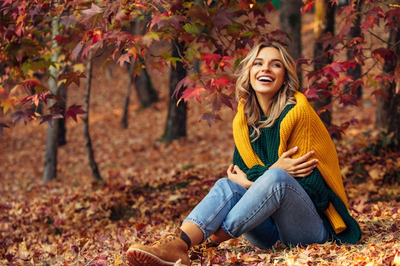 Woman Sitting in the Forrest with a Green and Yellow Sweater