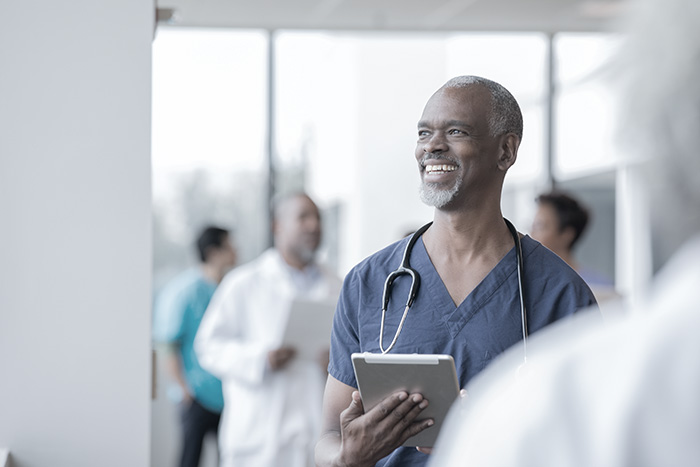 Doctor smiling while holding a clipboard