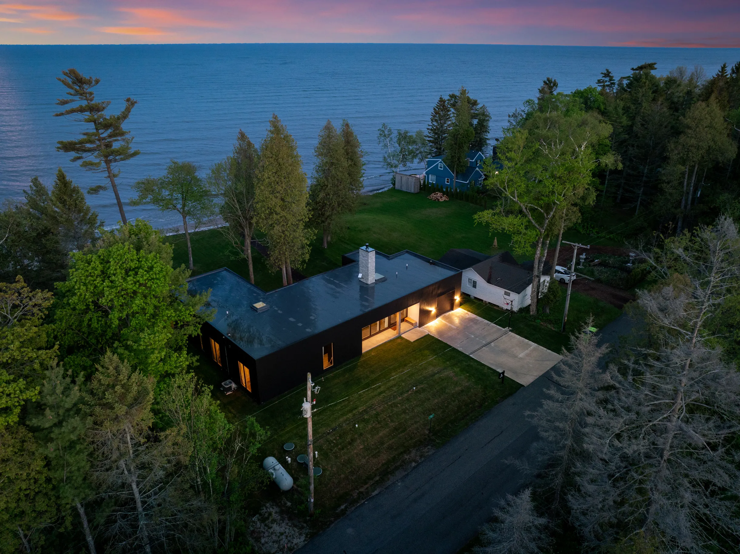 A dark house on the waterfront surrounded by trees