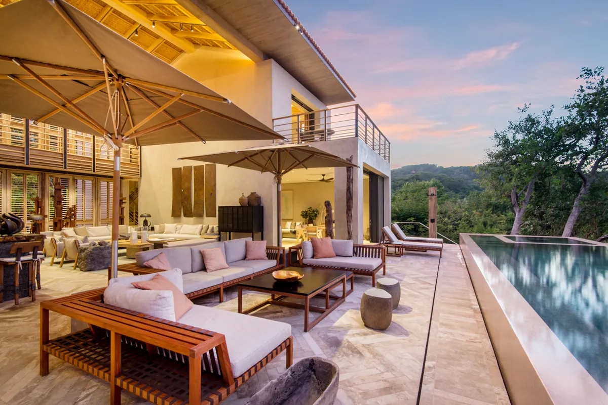 patio of a property with outdoor chairs, umbrellas, and a pool