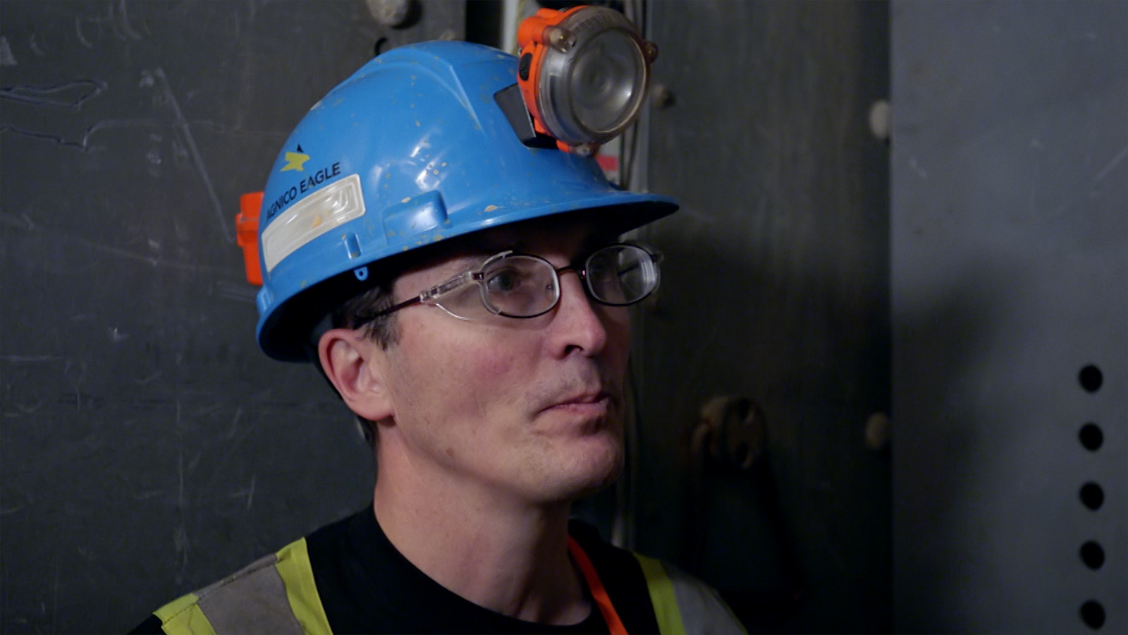 Pascal Laroche, Idris Elba’s guide, talks with Idris, wearing a blue safety hat with a light and fluorescent yellow stripes.