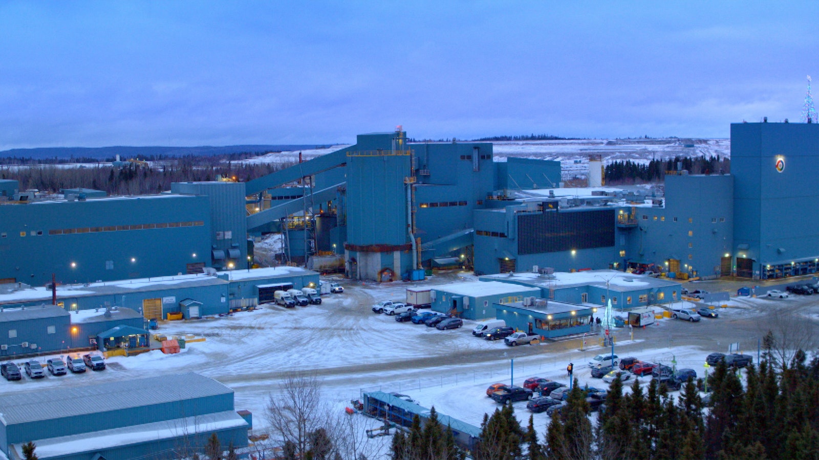 A wide shot of the LaRonde as if taken from a hill, showing the many green buildings atop the Canadian snow.