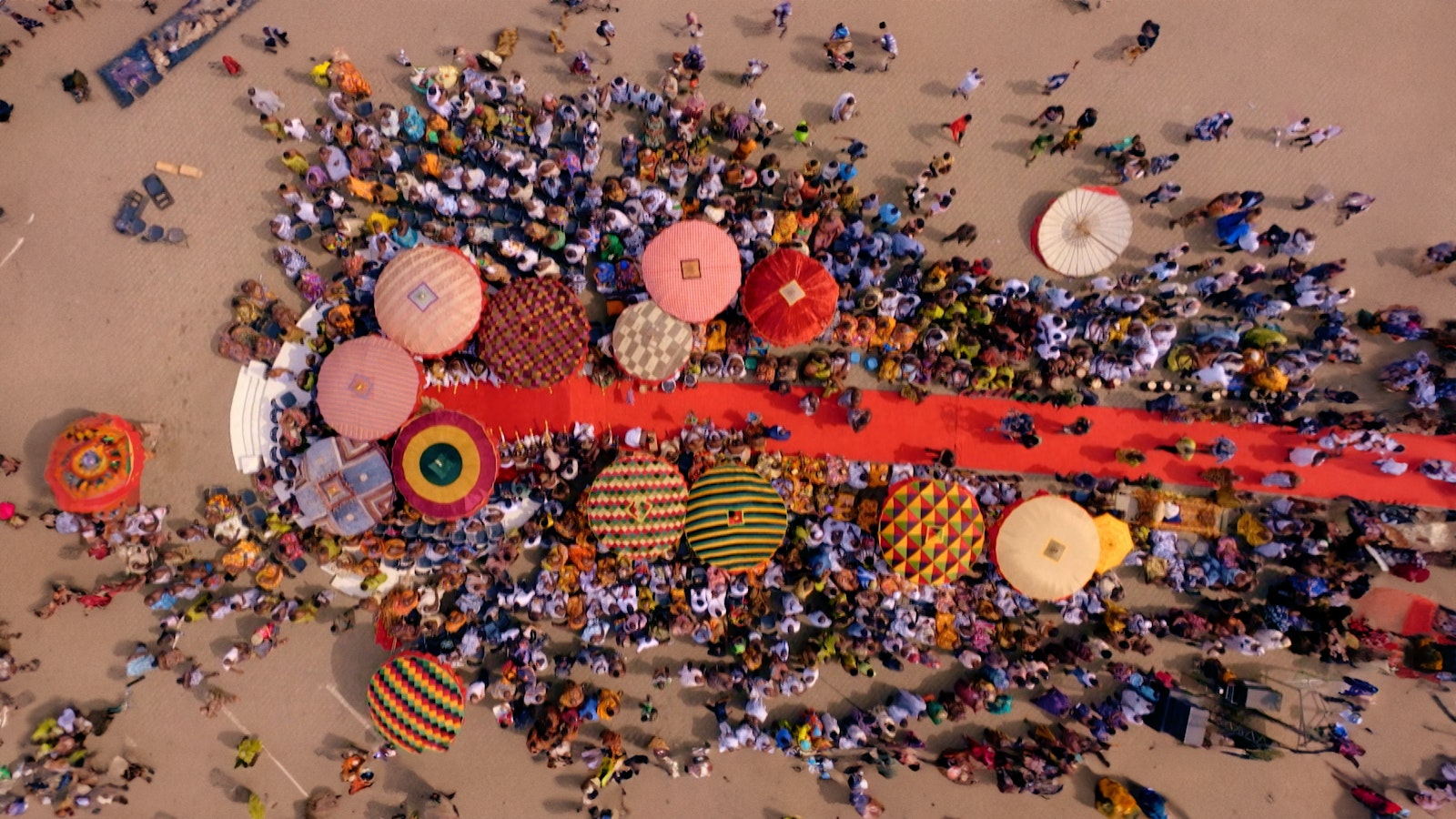 An aerial shot of the Akwasidae Festival with the red carpet leading to the king's throne surrounded by people and parasols.