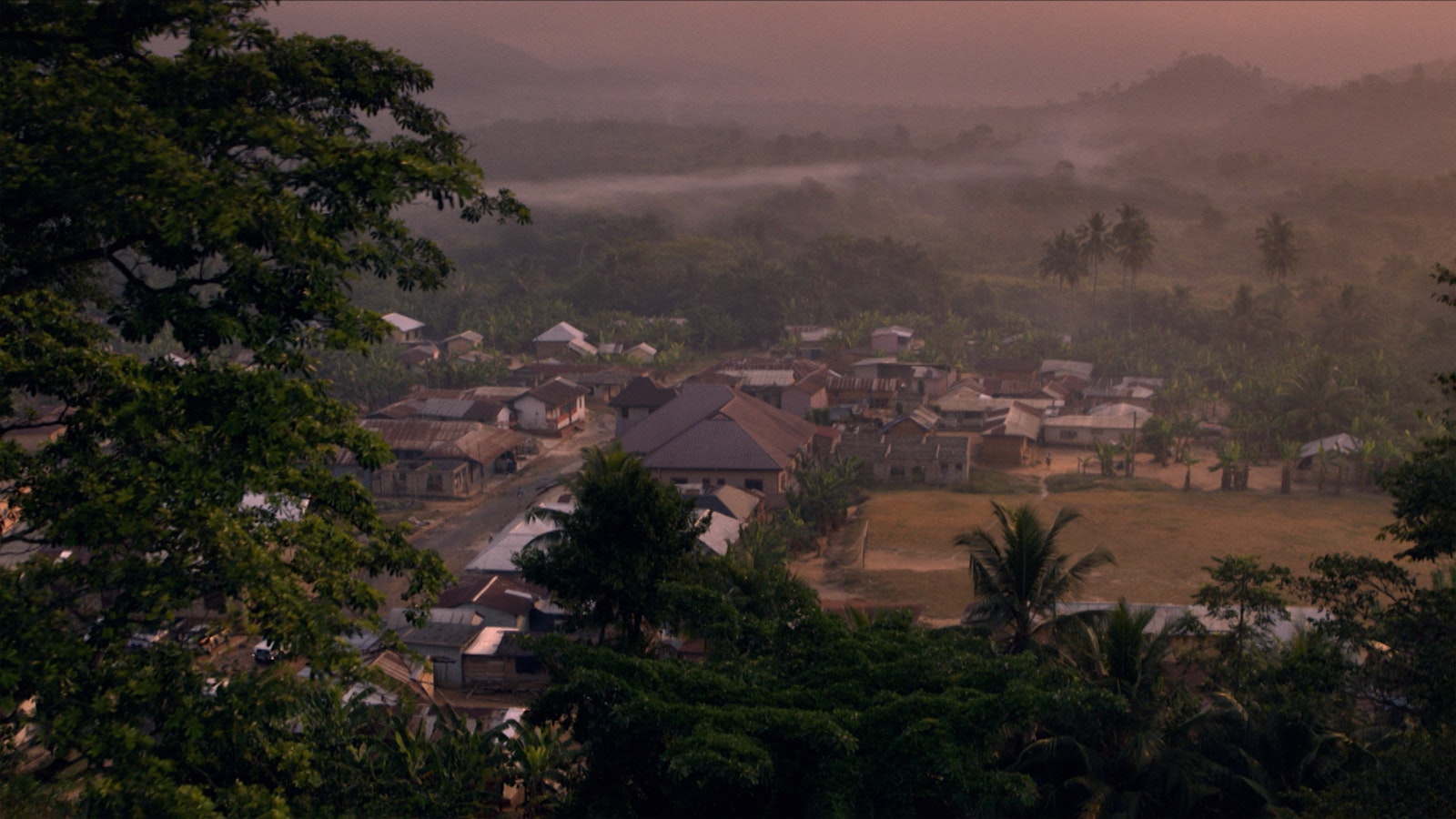 A birds-eye-view shot of the Ghanaian town being treated by the programme. Palm trees surround streets of suburban homes.