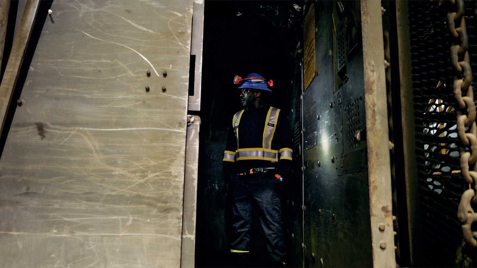 Dressed in full mine safety gear including fluorescent yellow straps, Idris Elba enters the lift at the LaRonde Complex.