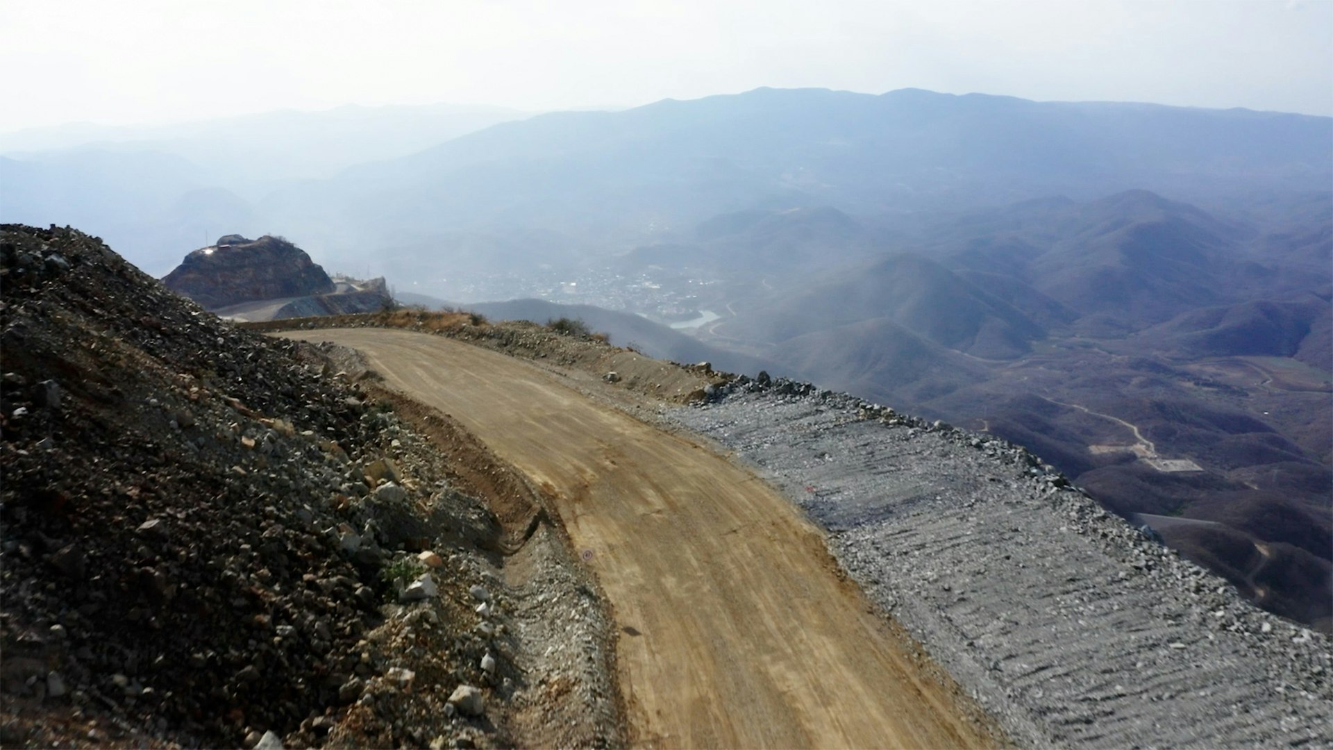 A track winding around the side of a mine at high altitude.