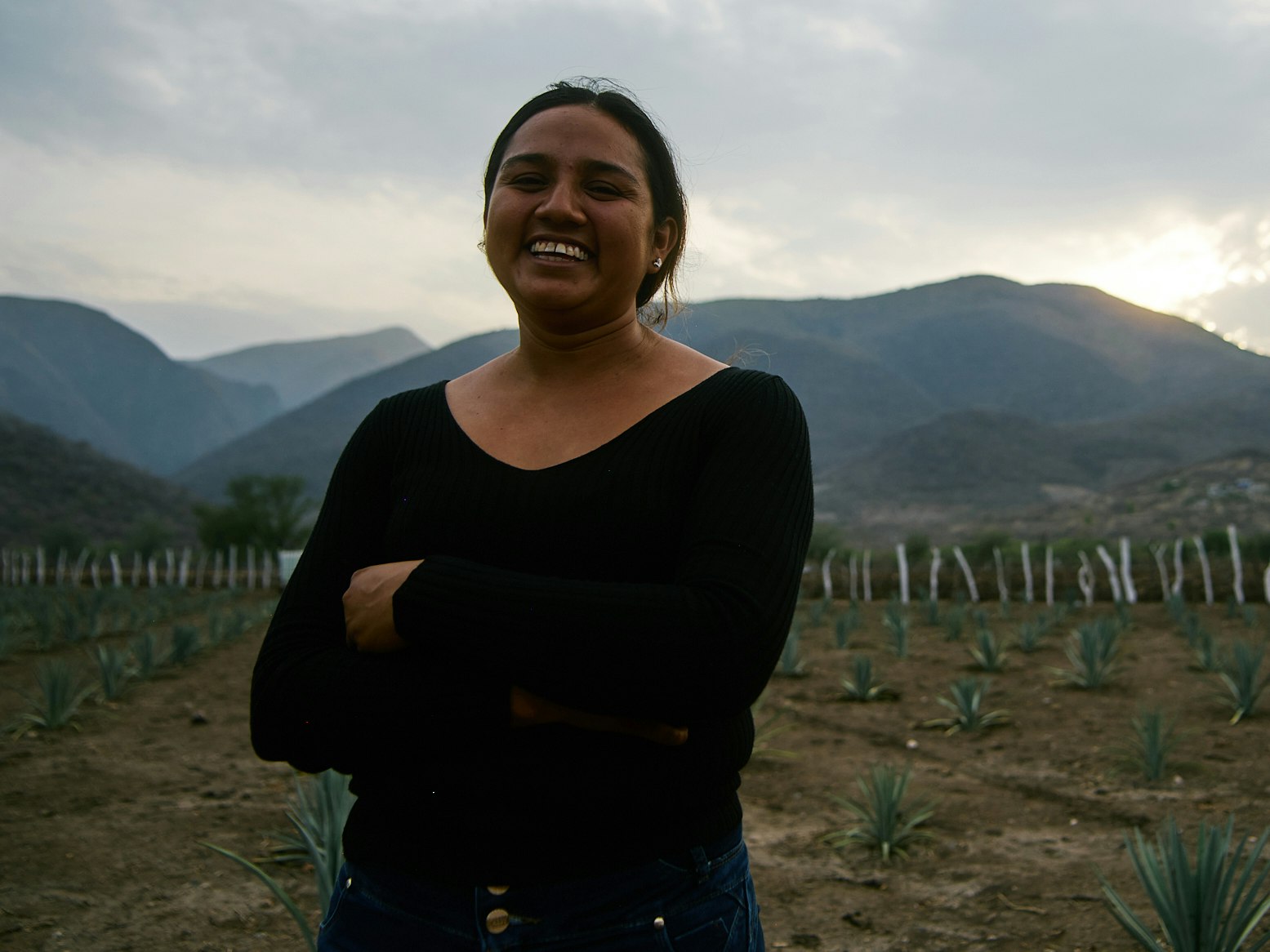 A woman standing in her field of crops.
