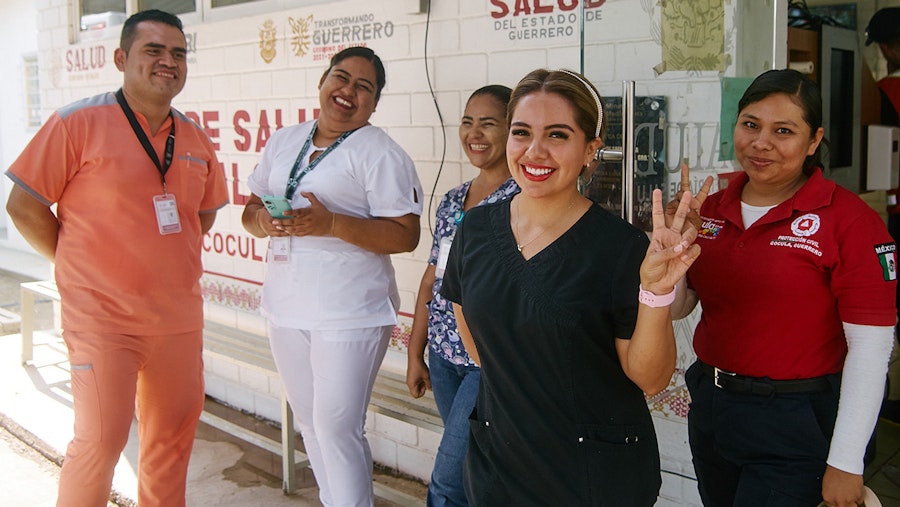 Healthcare professionals standing in front of a clinic.