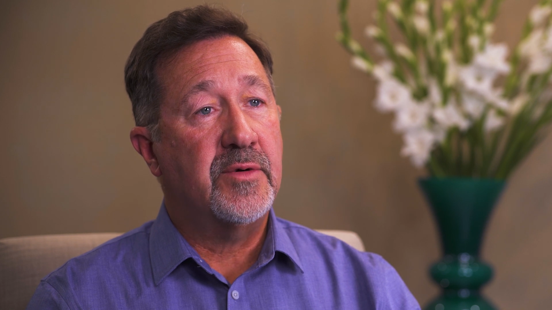 older gentleman in a purple button down during an interview