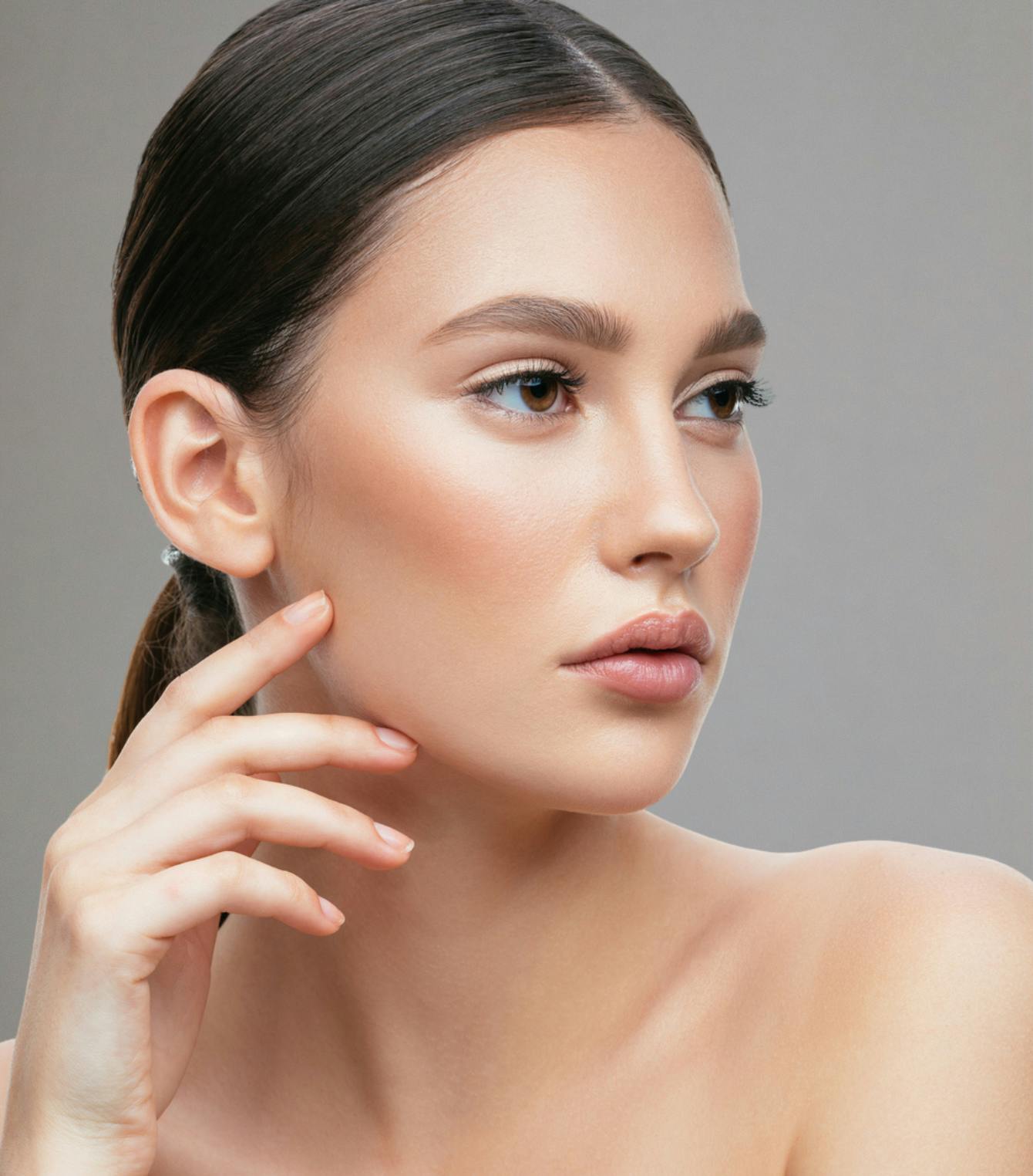 woman with clear skin touching cheek