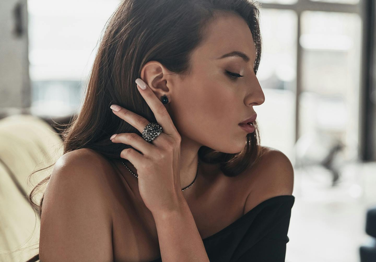 model pulling hair back behind her ear