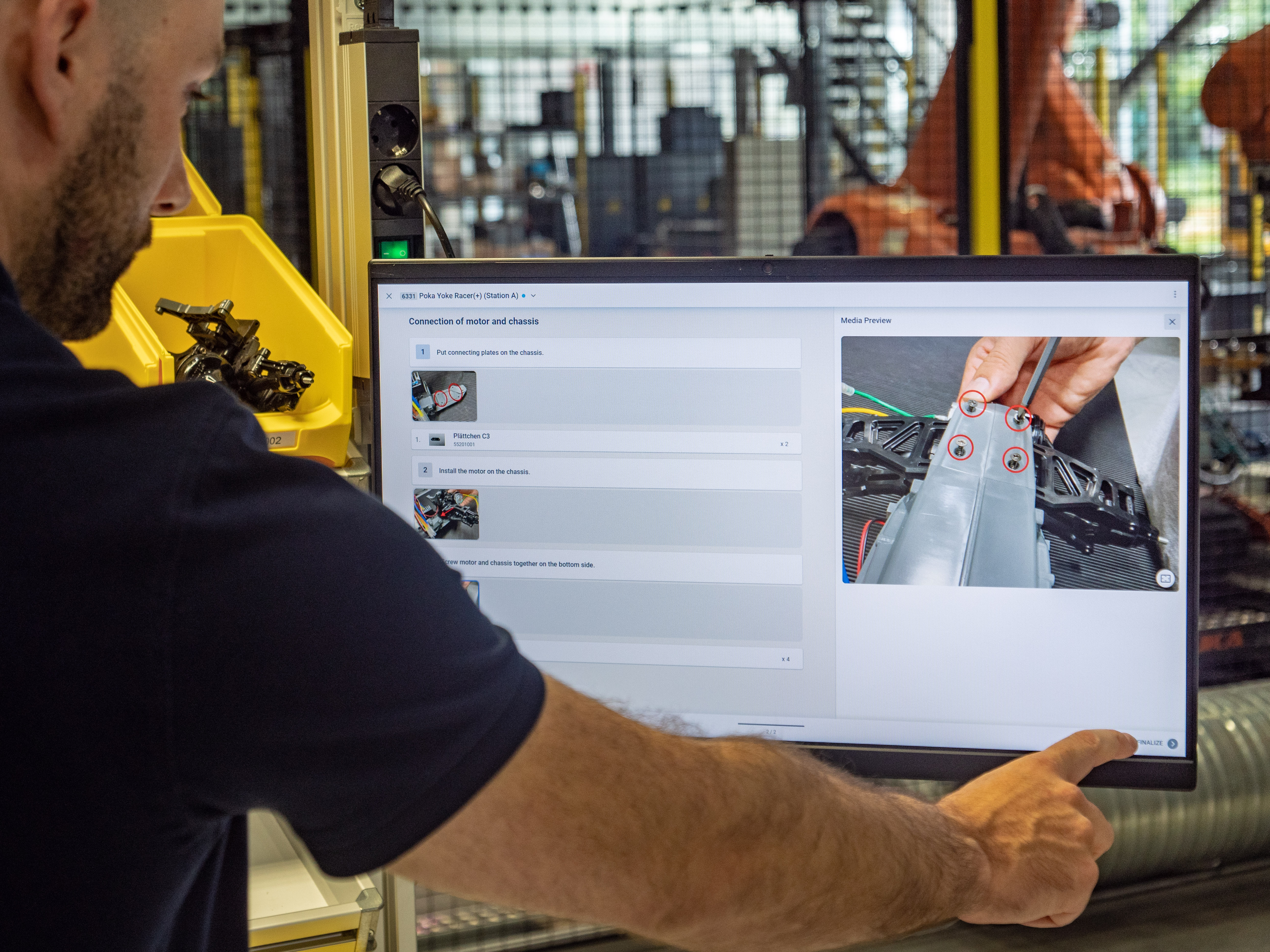 Worker uses digital work instruction software in assembly