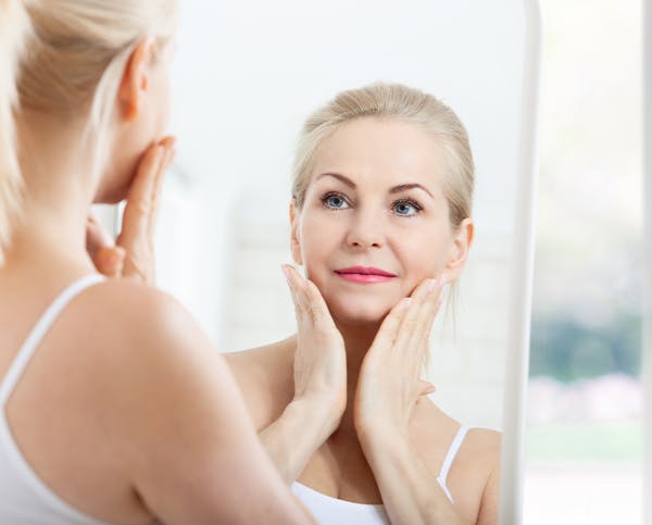 Woman admiring reflection in mirror