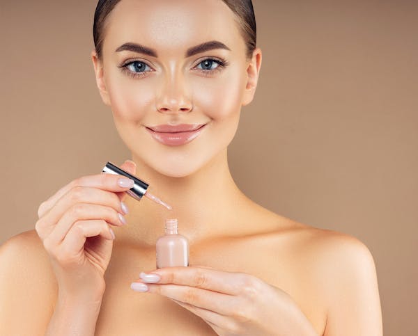 Woman with manicure holding a nail polish bottle