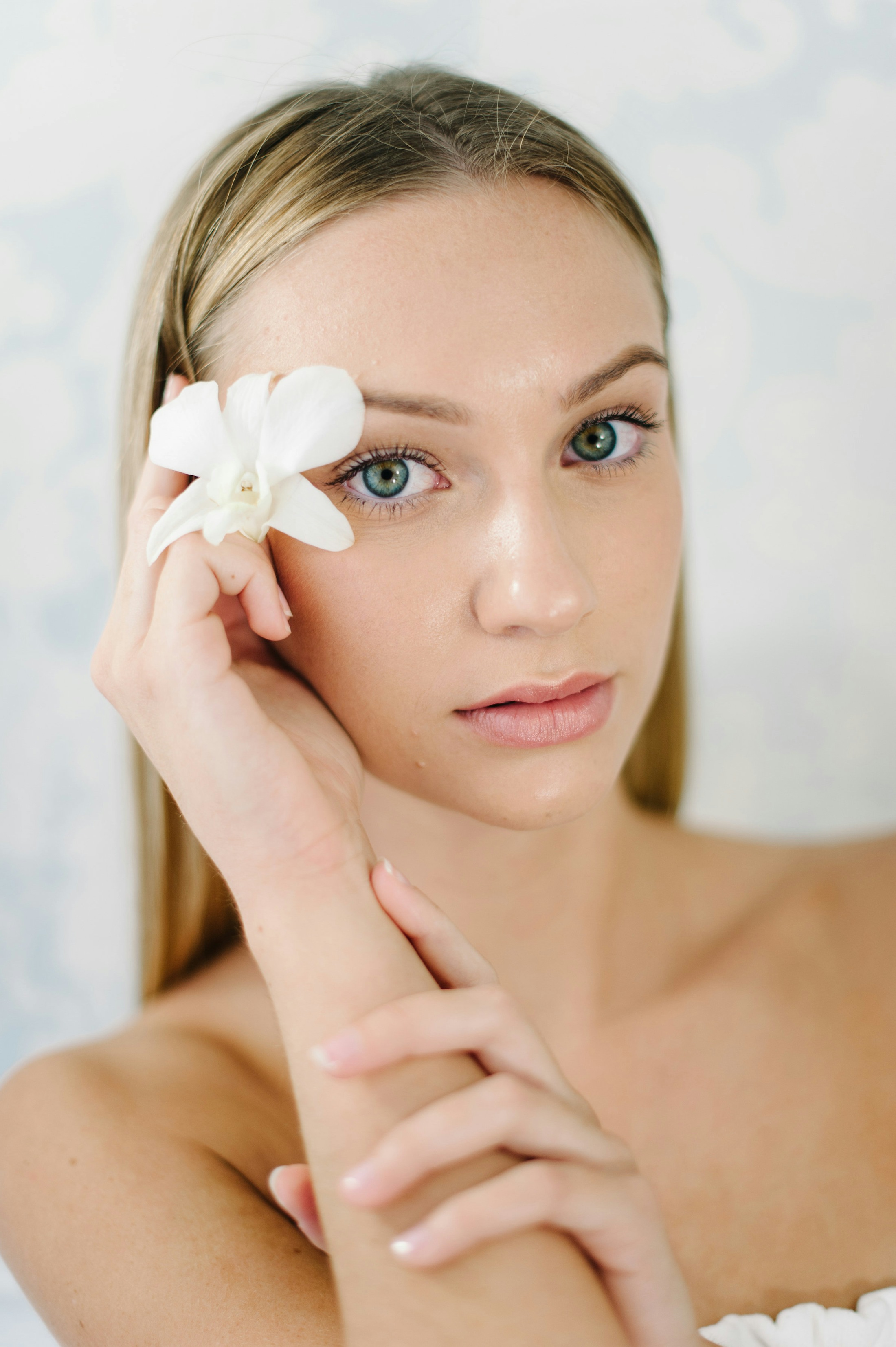 woman holding white flower in her hair