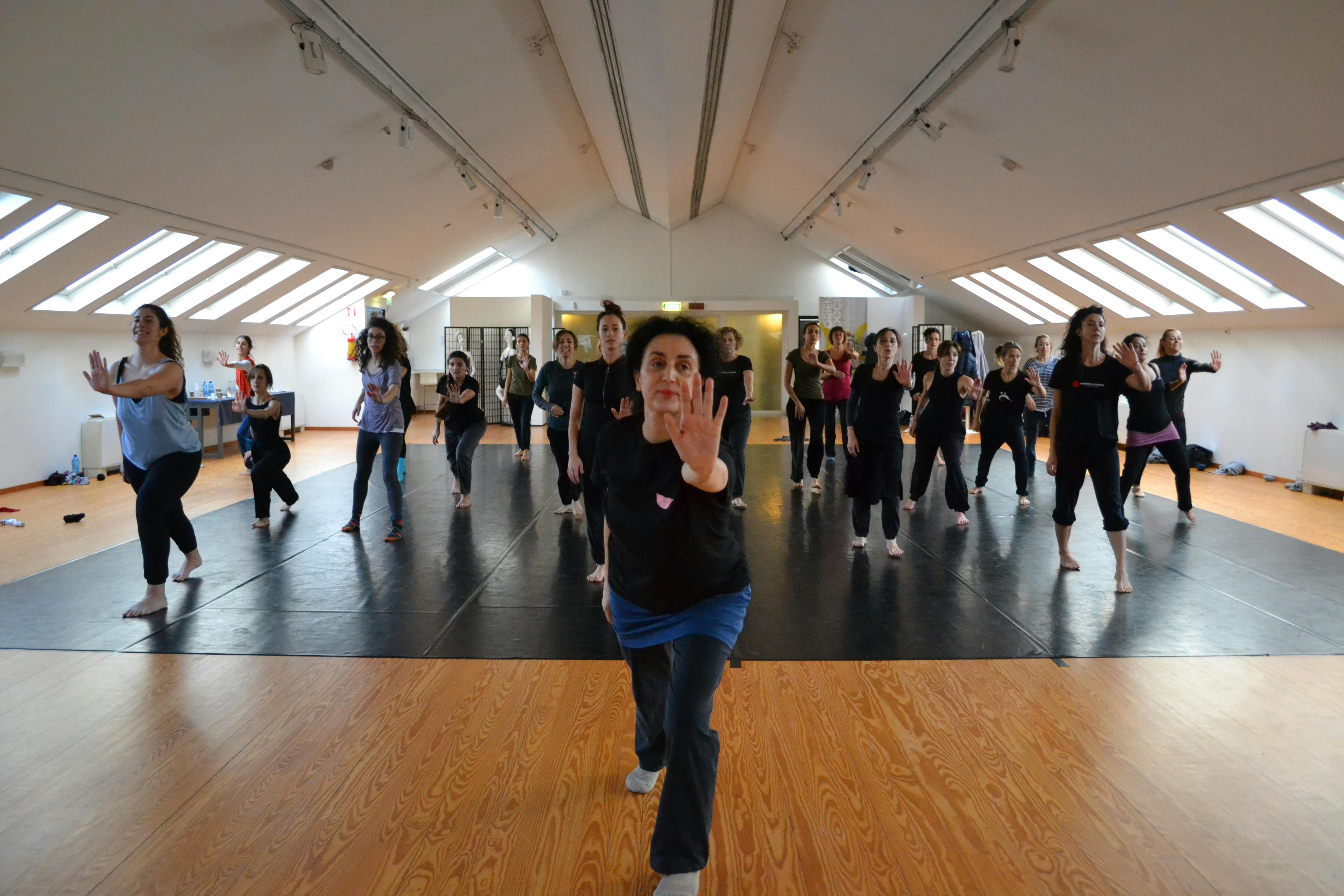 Gruppo di persone, con l'insegnante in prima fila, durante una lezione di danza livello intensivo