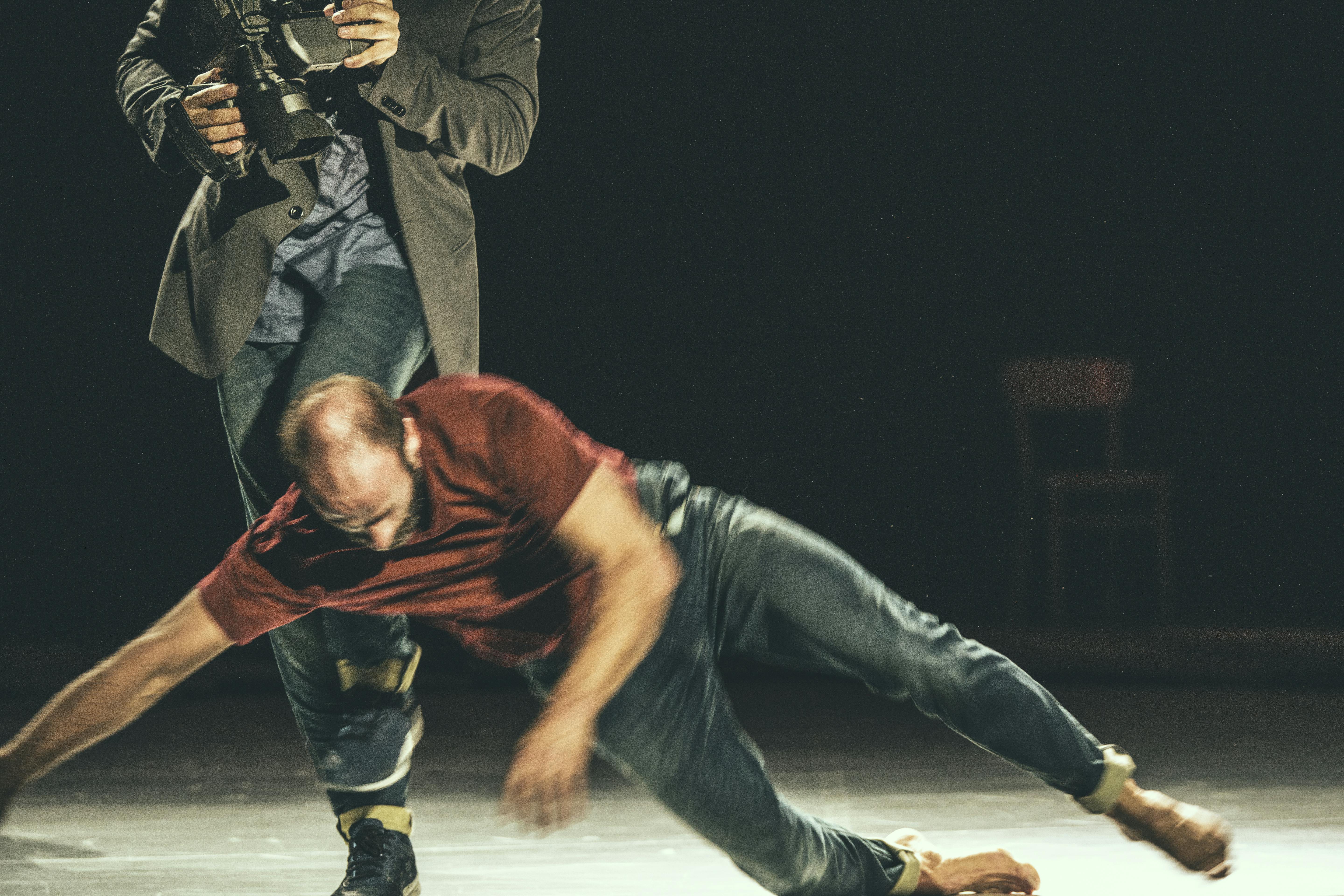 In front, a man is falling to the floor; behind, a second one is moving.