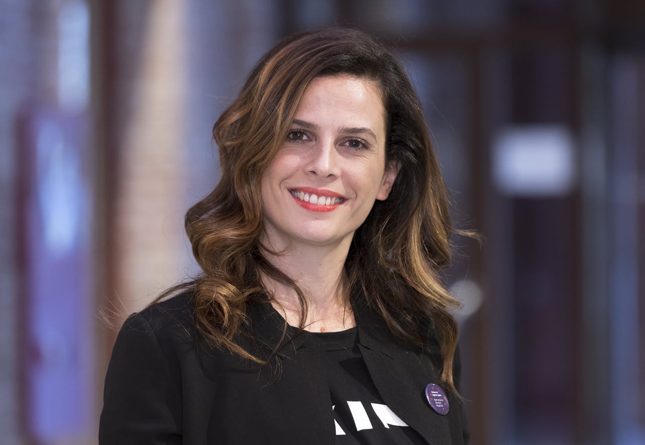 Foto a mezzobusto di Francesca Bria. Lei, capelli lunghi e mossi, sorride verso l'obbiettivo.