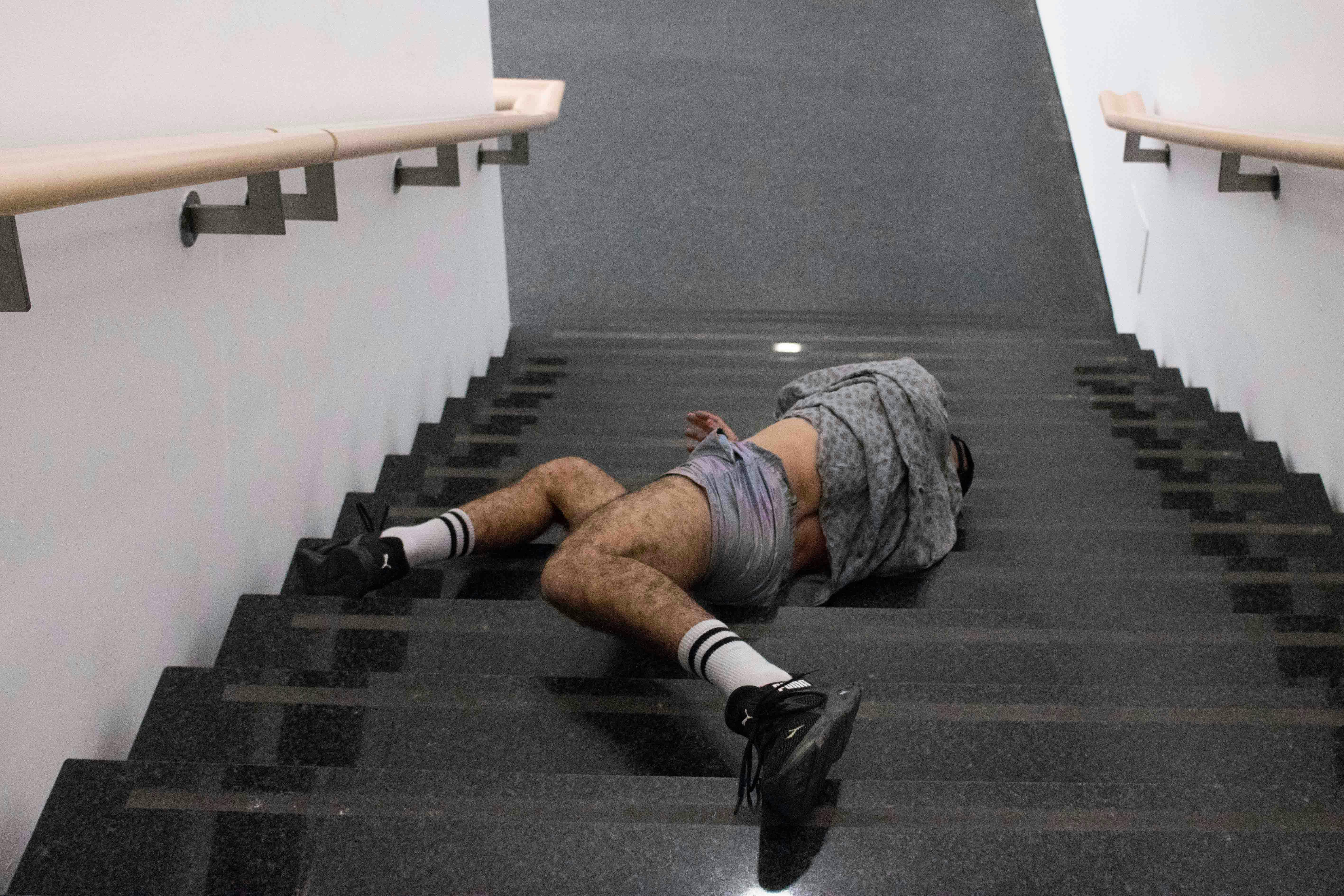 Daniele Ninarello is lying on a staircase in a disheveled position. The body is upside down, facing the base of the stairs.