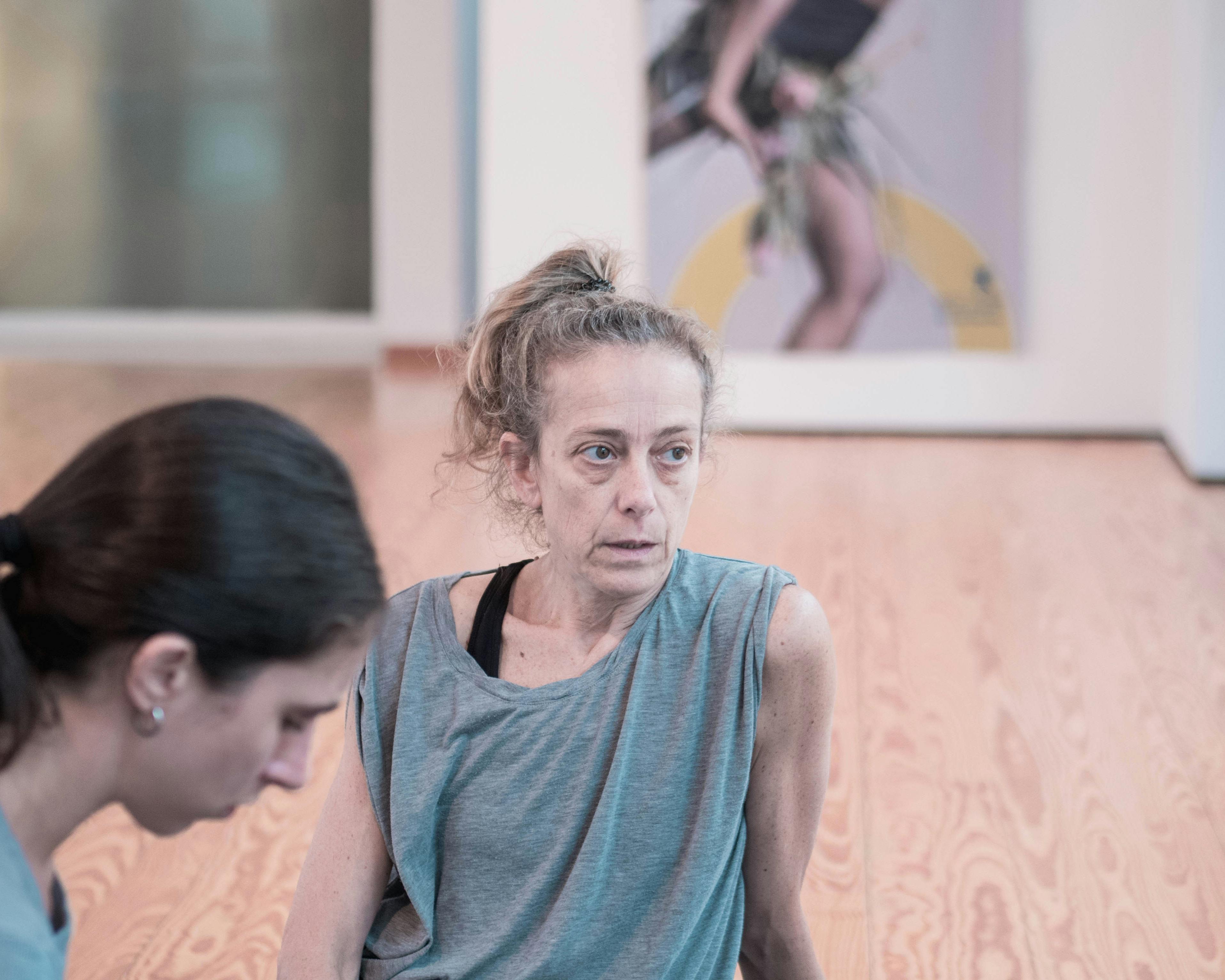 La coreografa Cristina Kristal Rizzo al lavoro nello Studio e parla con i danzatori. Accanto a lei una danzatrice ascolta.