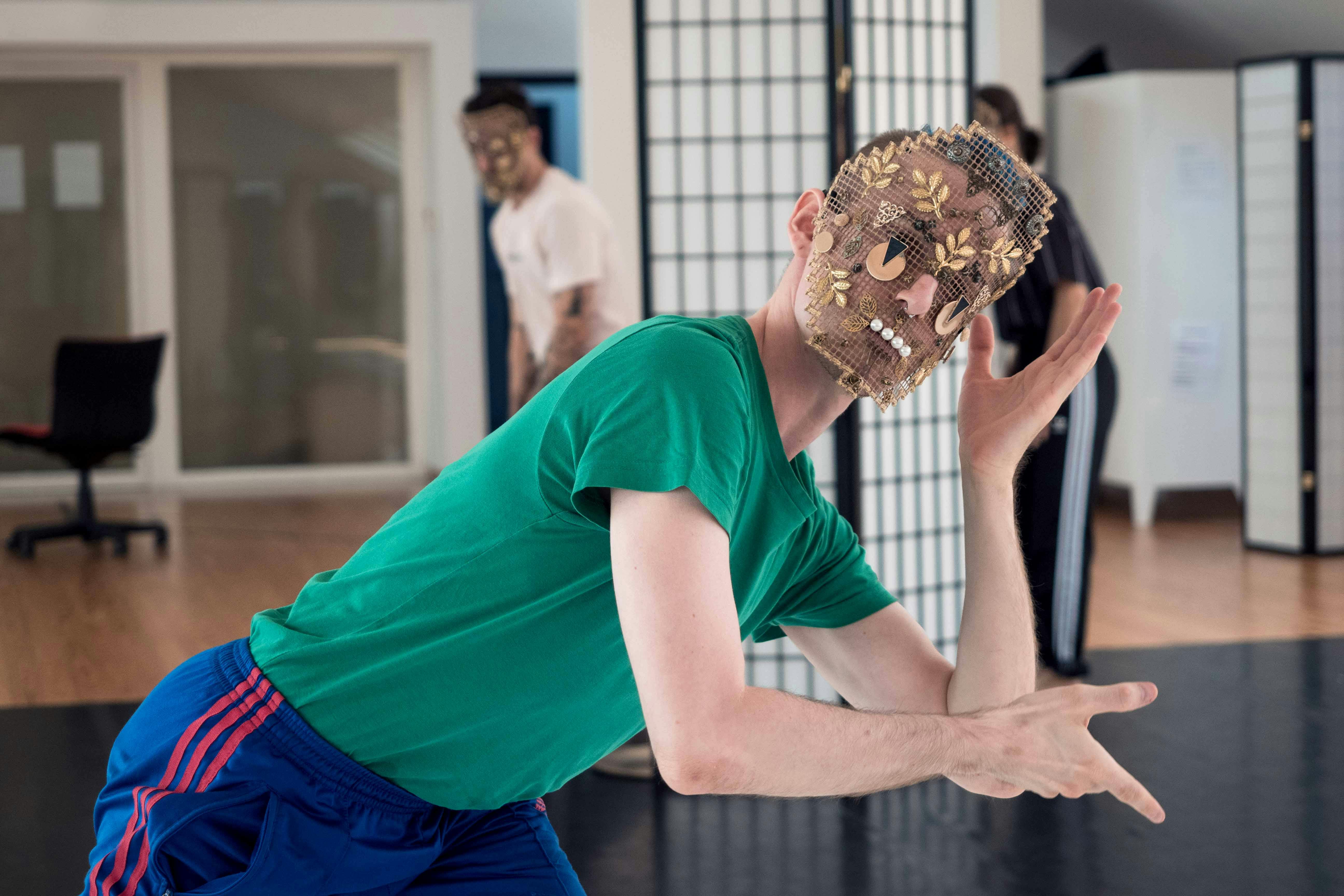 Nicola Galli during a rehearsal in the Studio He wears one of his masks, the torso is bent forward and sideways, the arms imitate a support for the head which is only pretending to lean on it.