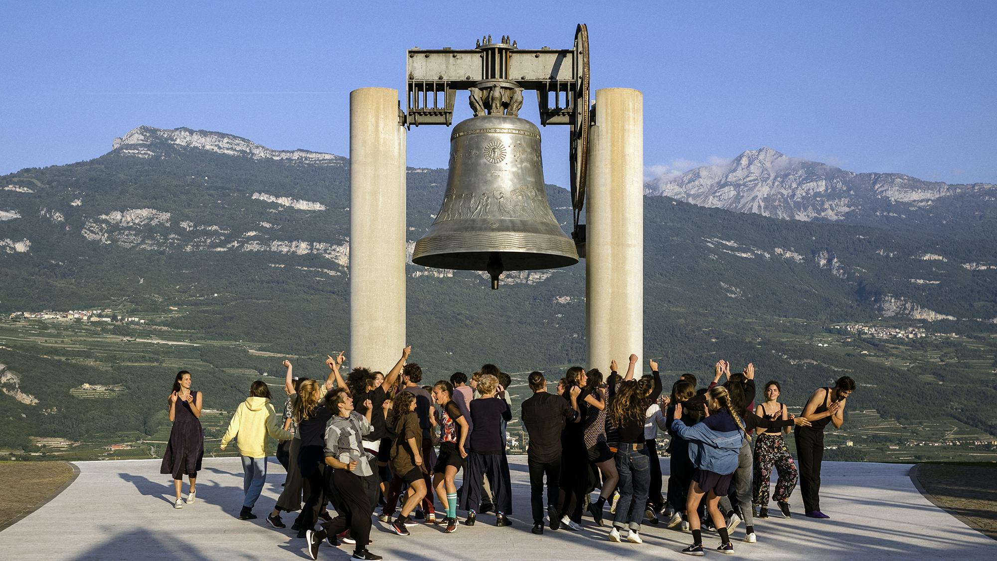 A group of performers dance at dawn under Maria Dolens, the Bell of the Fallen of Rovereto
