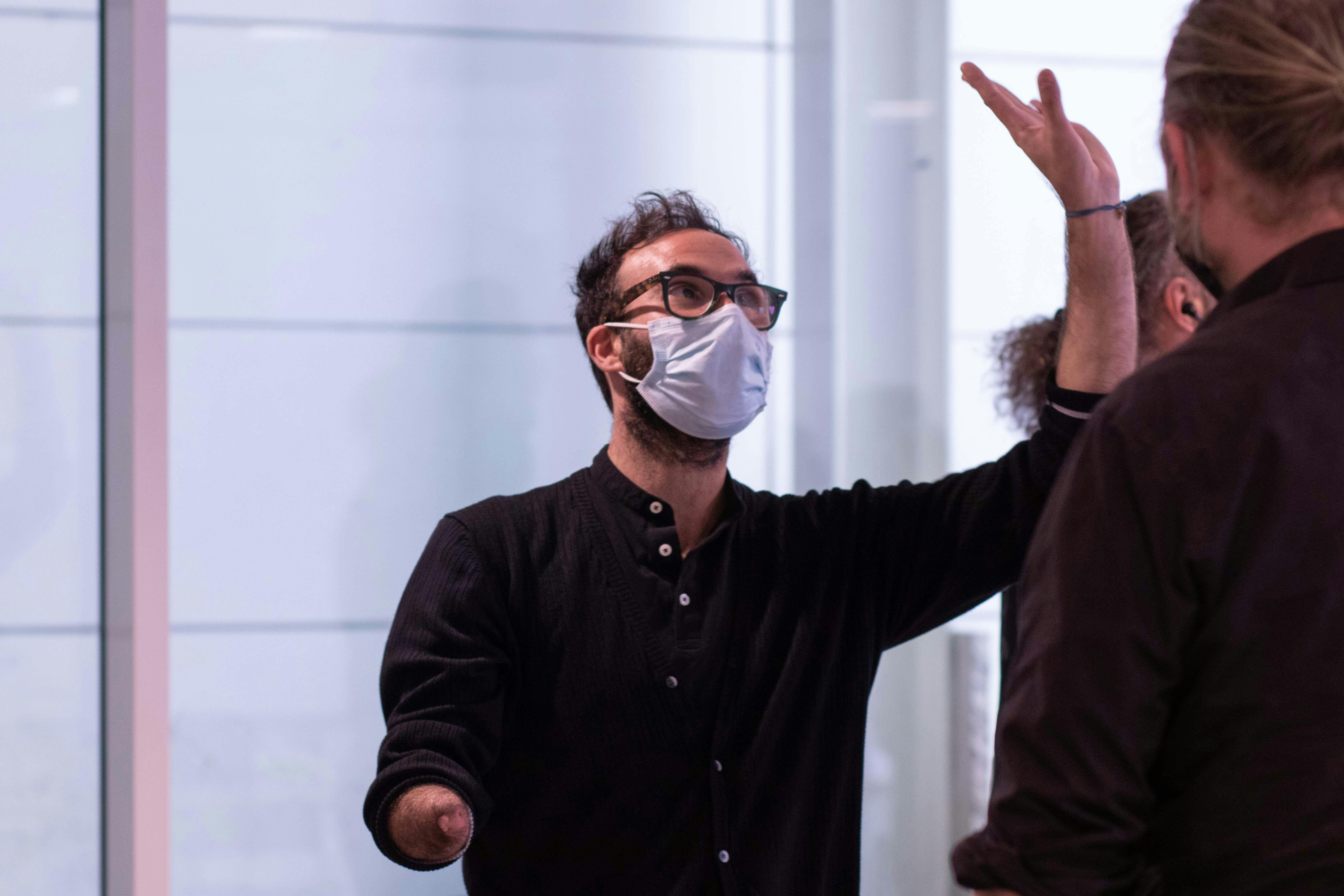 L'artista Aristide Rontini, partecipante al lab, mentre solleva il braccio sinistro verso l'alto con la mano aperta.