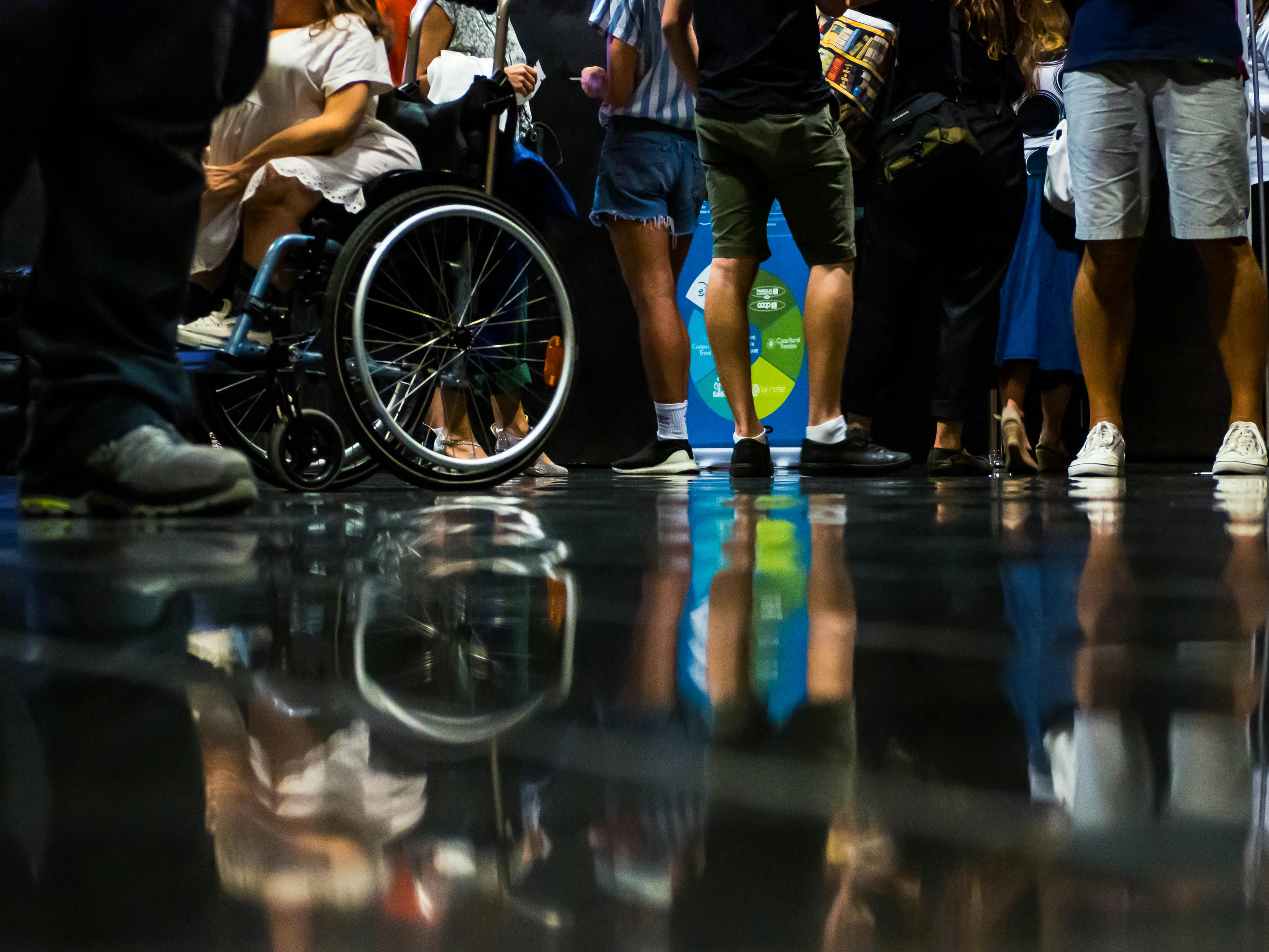 Ingresso del pubblico a teatro. Sono riconoscibili persone sia con che senza disabilità.