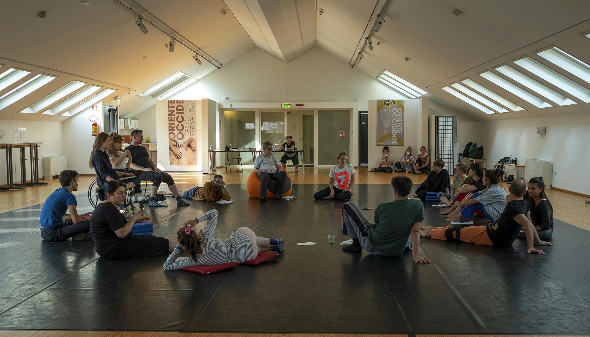 Participants of the international workshop Europe Beyond Access sitting in a circle in the spaces of Oriente Occidente Studio.