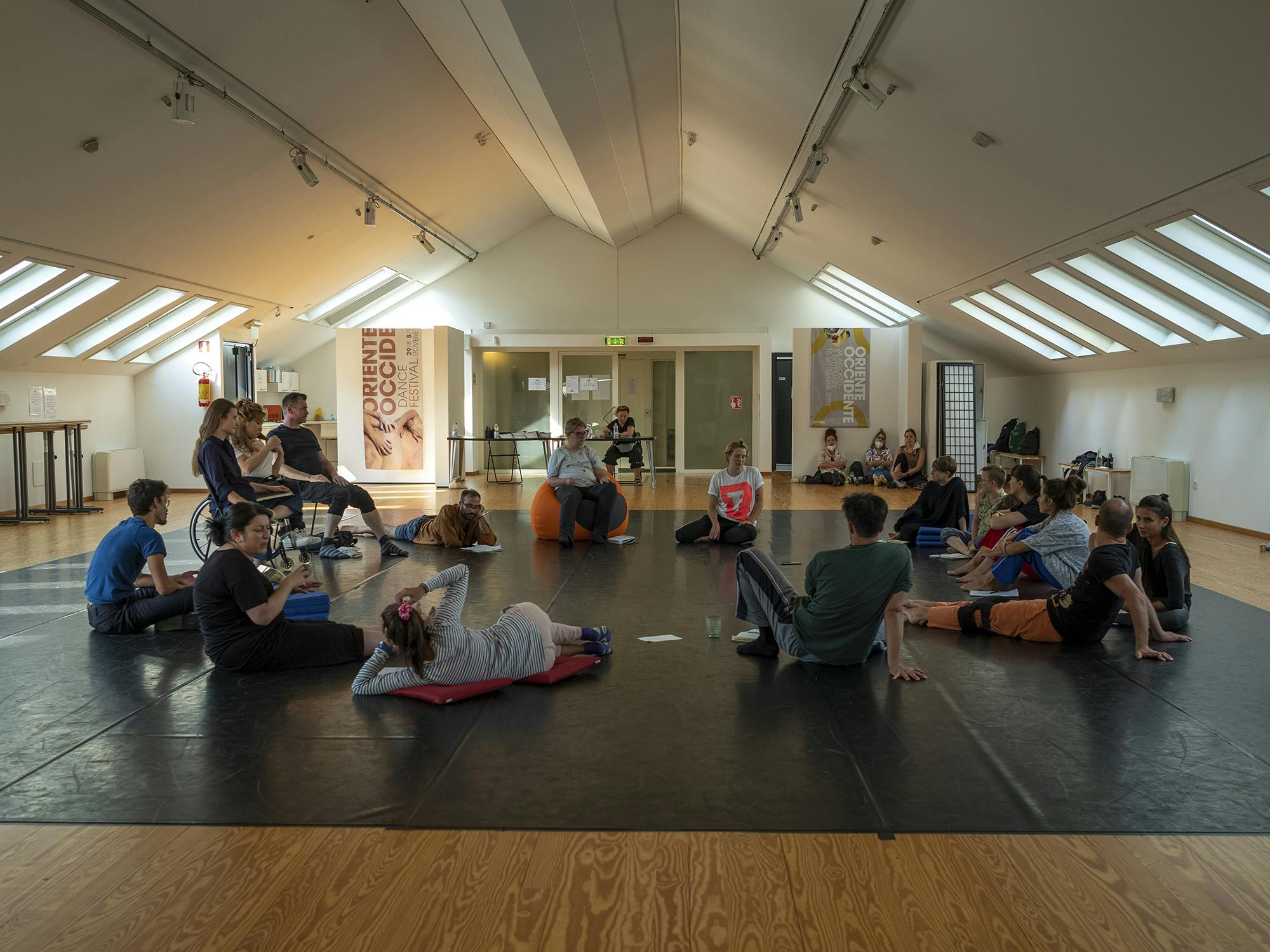 Participants of the international workshop Europe Beyond Access sitting in a circle in the spaces of Oriente Occidente Studio.