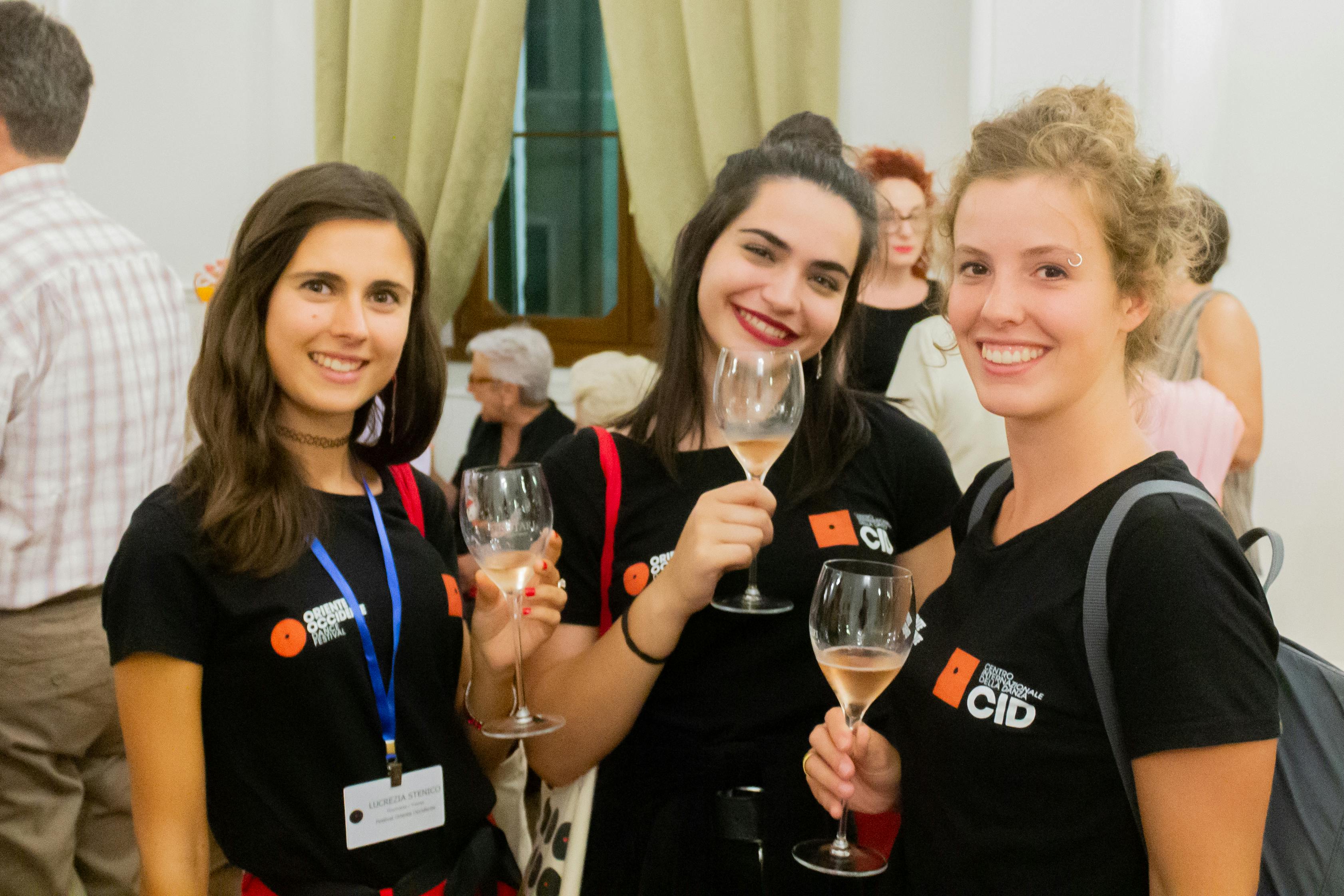 Tre ragazze del personale del festival brindano 