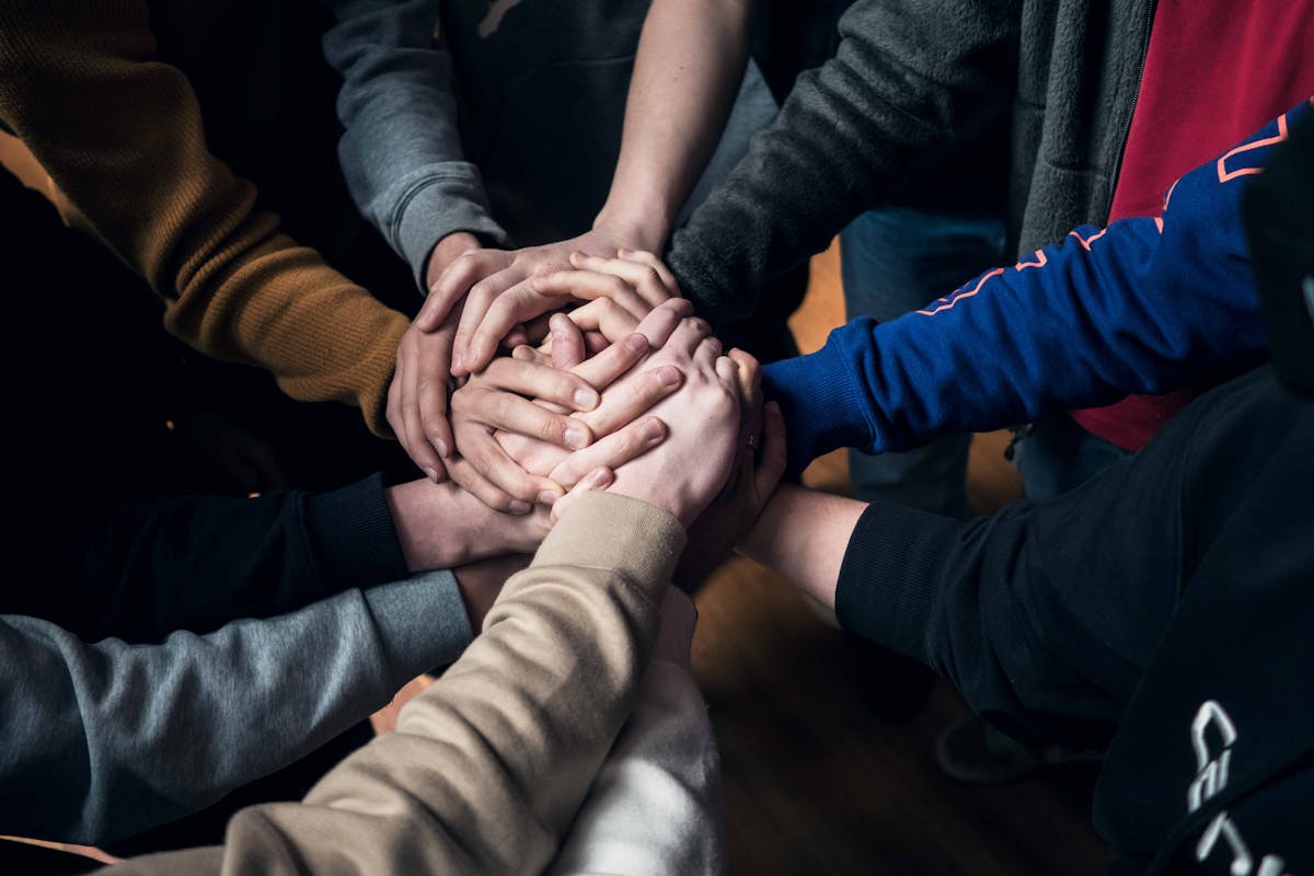 ragazzi in cerchio che si uniscono le mani 