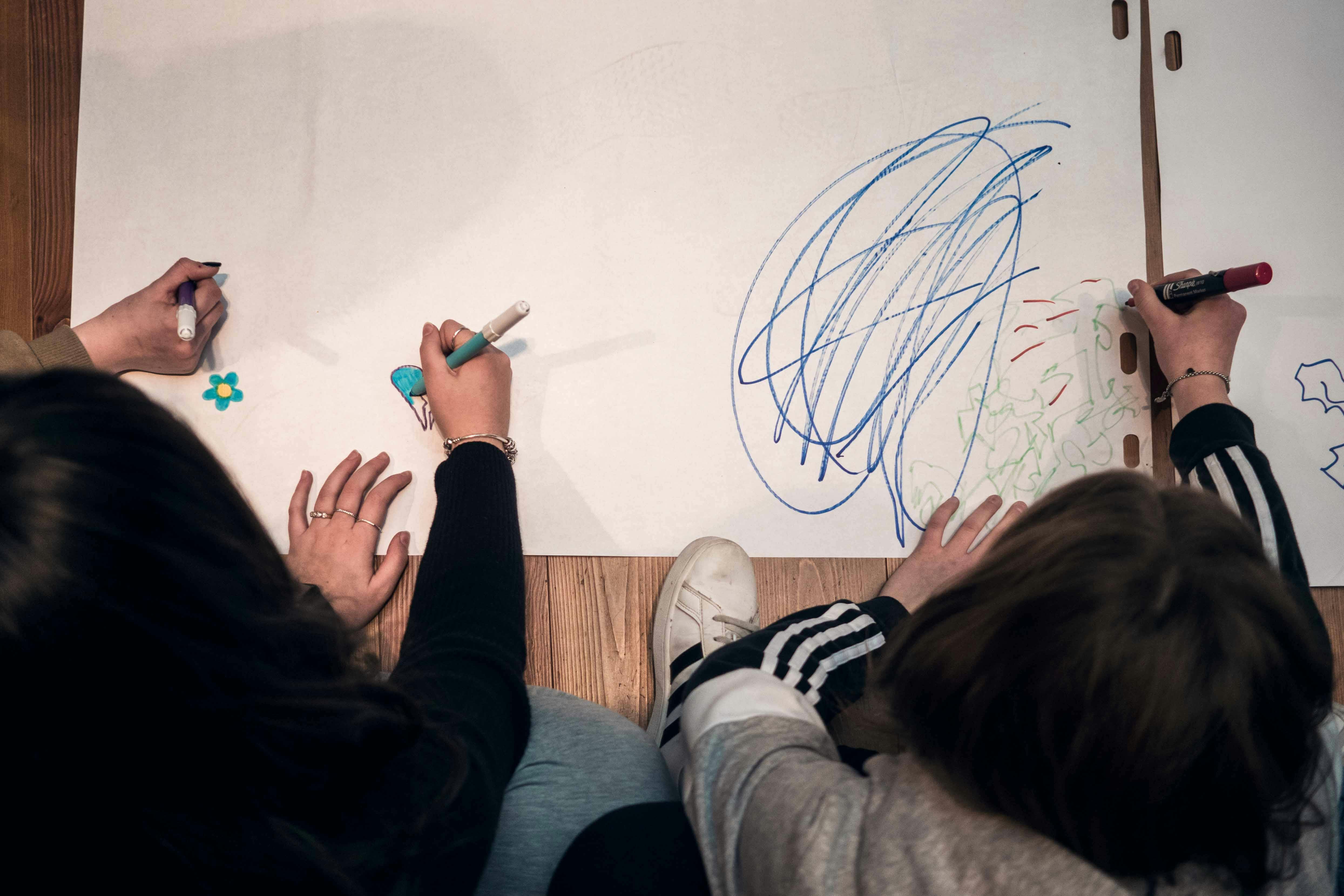 ragazzi che disegnano su fogli bianchi 