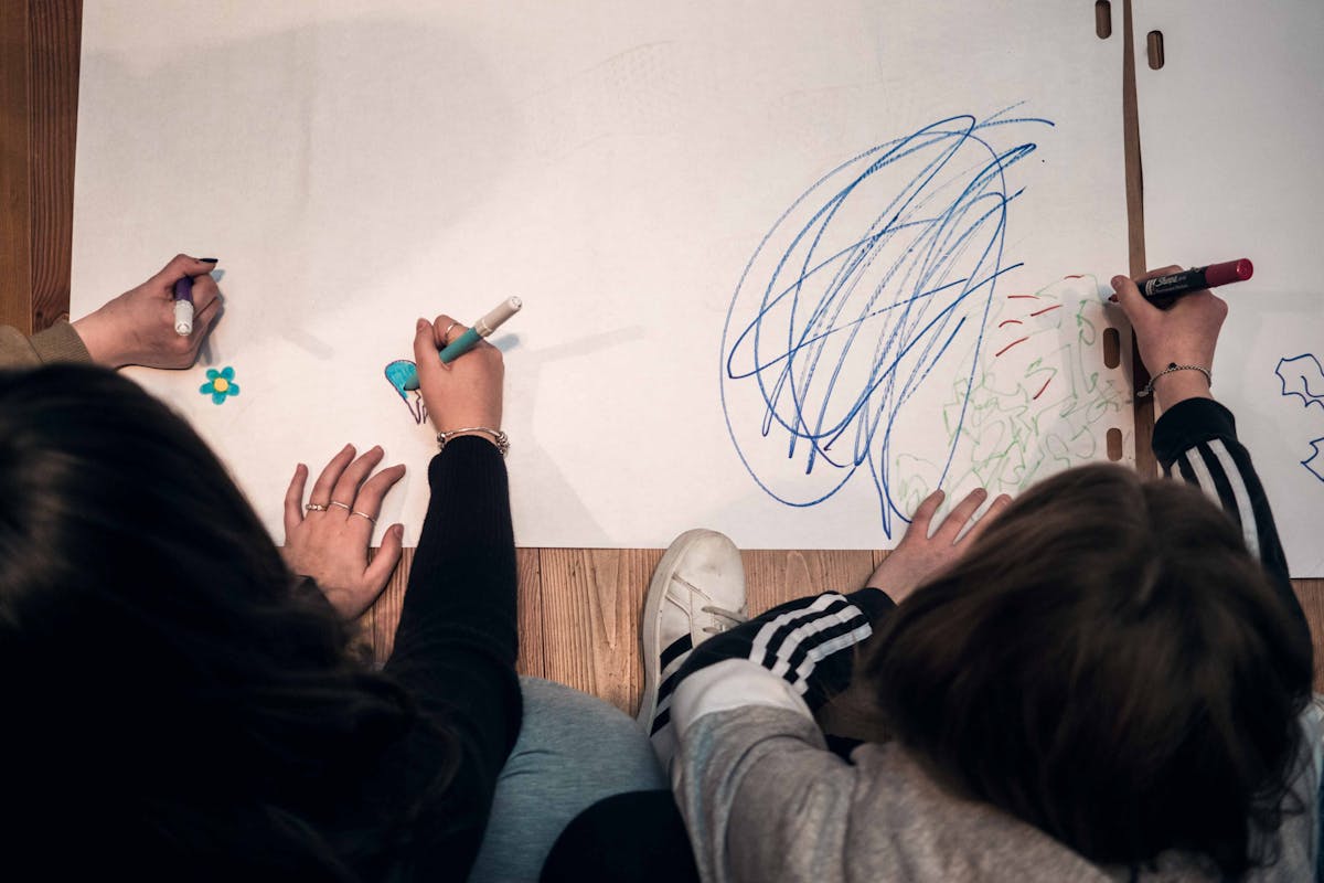 ragazzi che disegnano su fogli bianchi 