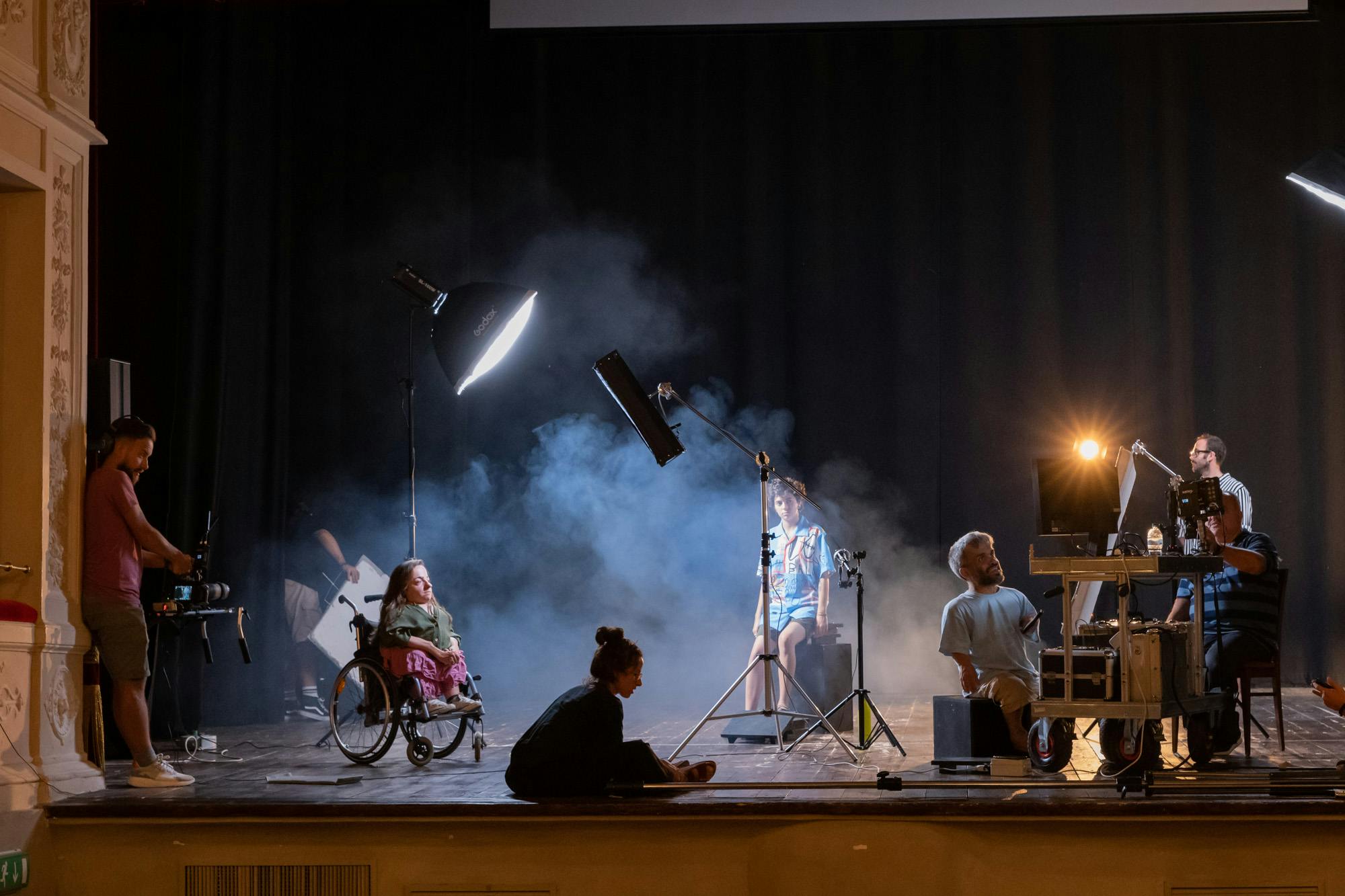 I performer sono sul palco di un teatro in diverse posizioni