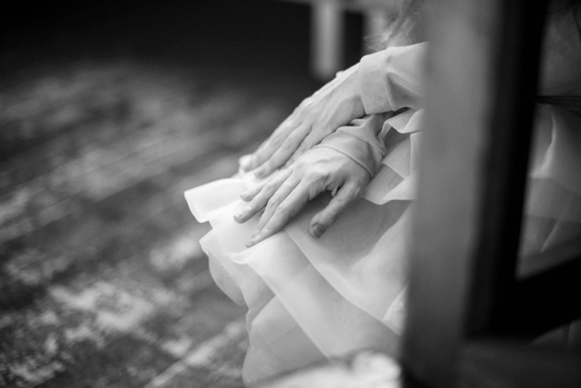 Black and white photo of hand resting on a skirt