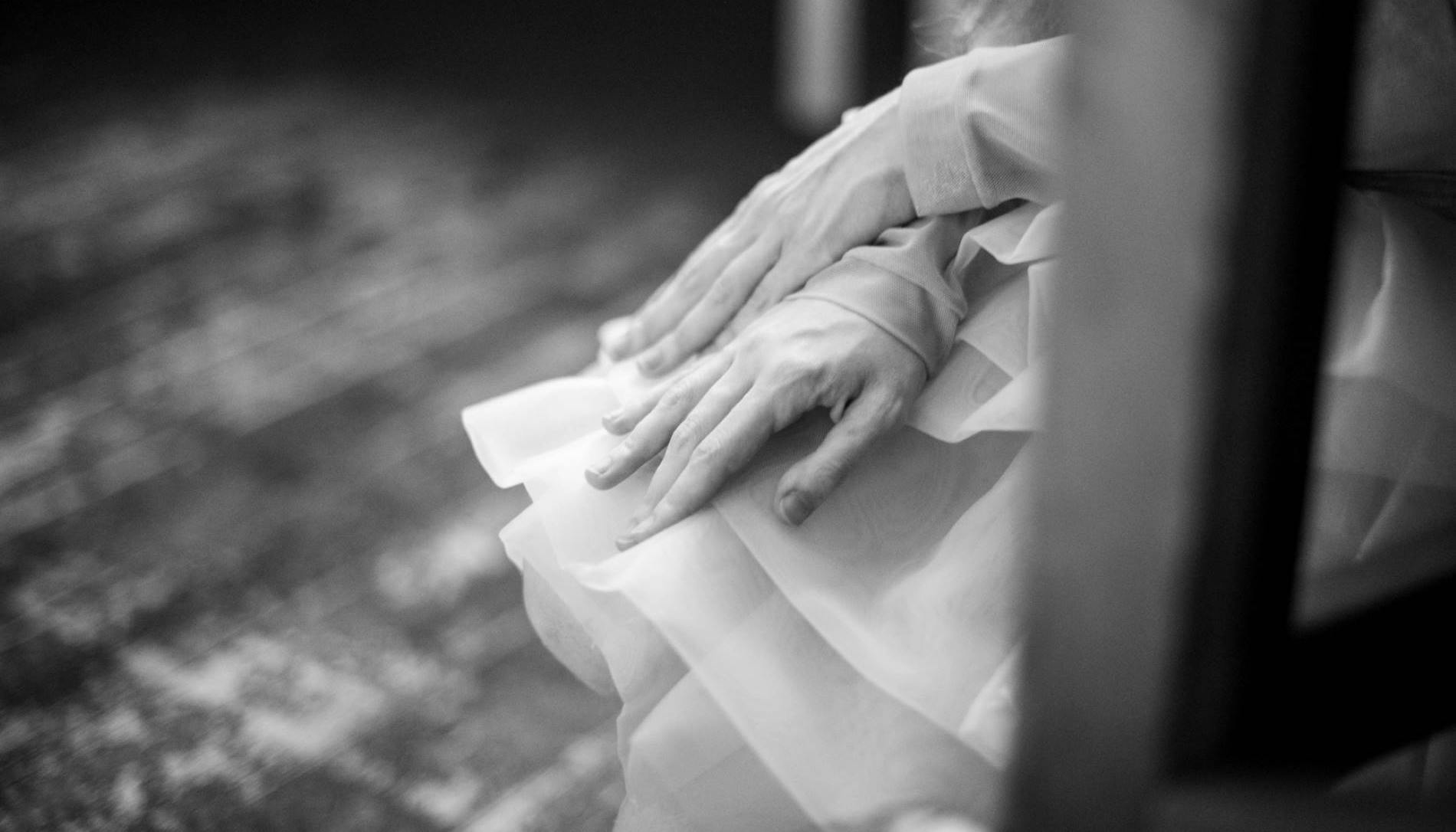 Black and white photo of hand resting on a skirt