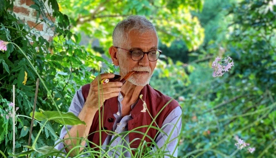 Fabrice Olivier Dubosc with a pipe in his mouth in nature