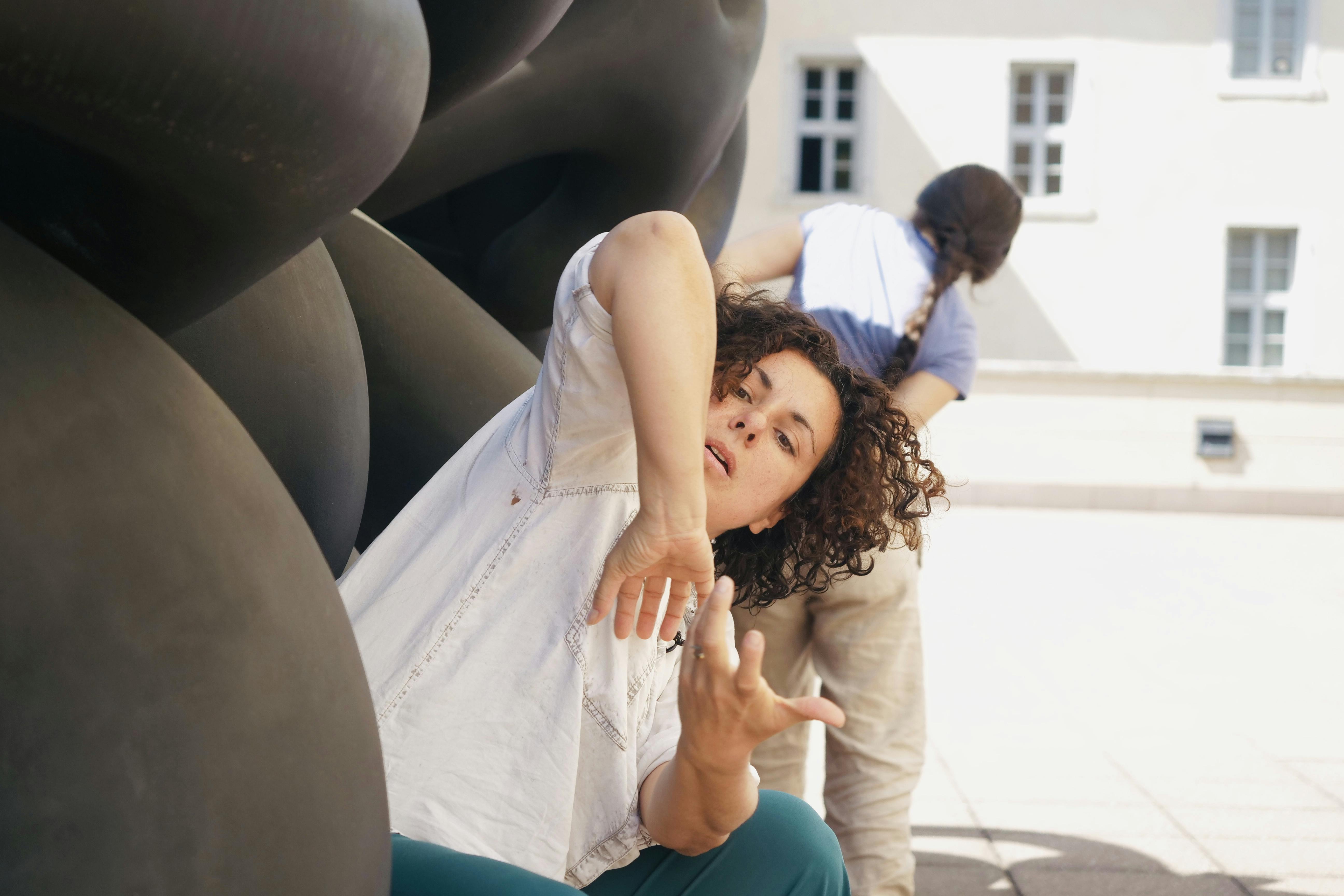 The dancer is in the center of the lens, on the left a Mart sculpture partially covers her figure. 